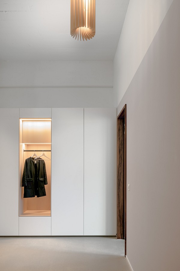 Garderobenschrank in Loft-Wohnung mit beleuchteter Nische in Eschenholz.